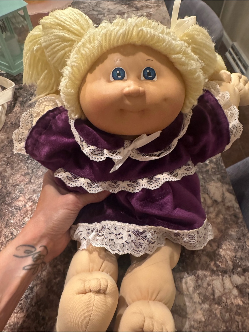 A Cabbage Patch Kid doll with blonde yarn hair and a purple dress - Picture 2 of 11